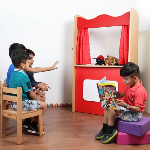 kids playing with puppet theater in kindergarten